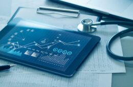 平板电脑上的医疗保健业务概念，医疗检查和业务增长图表数据，后台是医生的健康报告剪贴板。