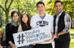 四名CWRU学生举着写有“CWRU欢迎你”的牌子