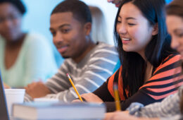 学生们在教室里看着笔记本电脑，这是多样性和包容性努力的一部分
