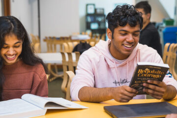 两名学生微笑着阅读的照片