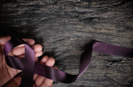 一张手握紫色意识丝带的照片