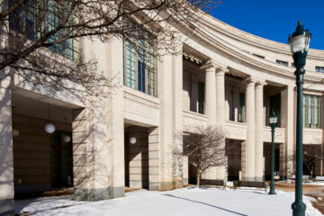 开尔文·史密斯图书馆的外部照片，前面的地面上有雪，头顶上有蓝天