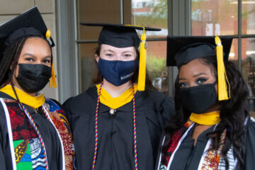 三名凯斯西储大学毕业生在202狗万客户端1年毕业典礼上戴着面具拍照