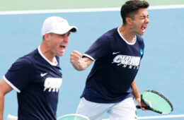 两名凯斯西储大学男子网球运狗万客户端动员在球场上欢呼的照片